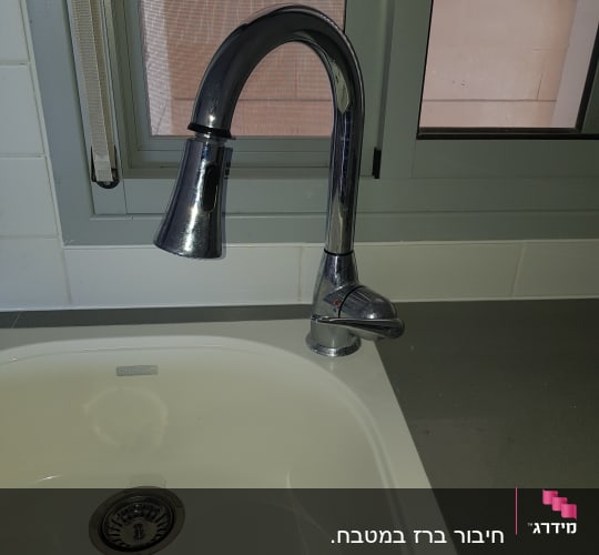 ברז מטבח נירוסטה מעל כיור לבן